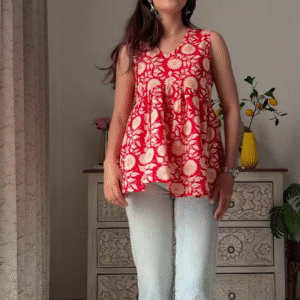 Women’s Sleeveless Red Floral Top with Light Blue Flared Jeans – Indo-Western Casualwear Styled with Vintage Decor Backdrop